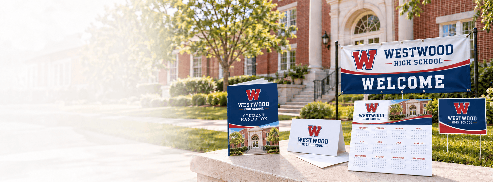 Custom school printing including a student handbook, note card, poster calendar, welcome banner and yard sign in front of Westwood High School